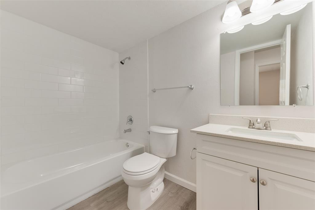 1112 Terrace Trail Carrollton, TX 75006 - Photo 14 of 20 a bathroom with a toilet a sink a mirror and a bathtub