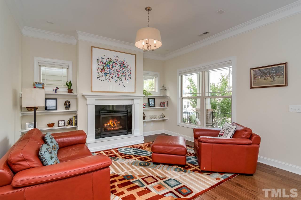 1409 Rodessa Run Raleigh, NC 27607 - Photo 4 of 25 a living room with furniture a chandelier and a fireplace