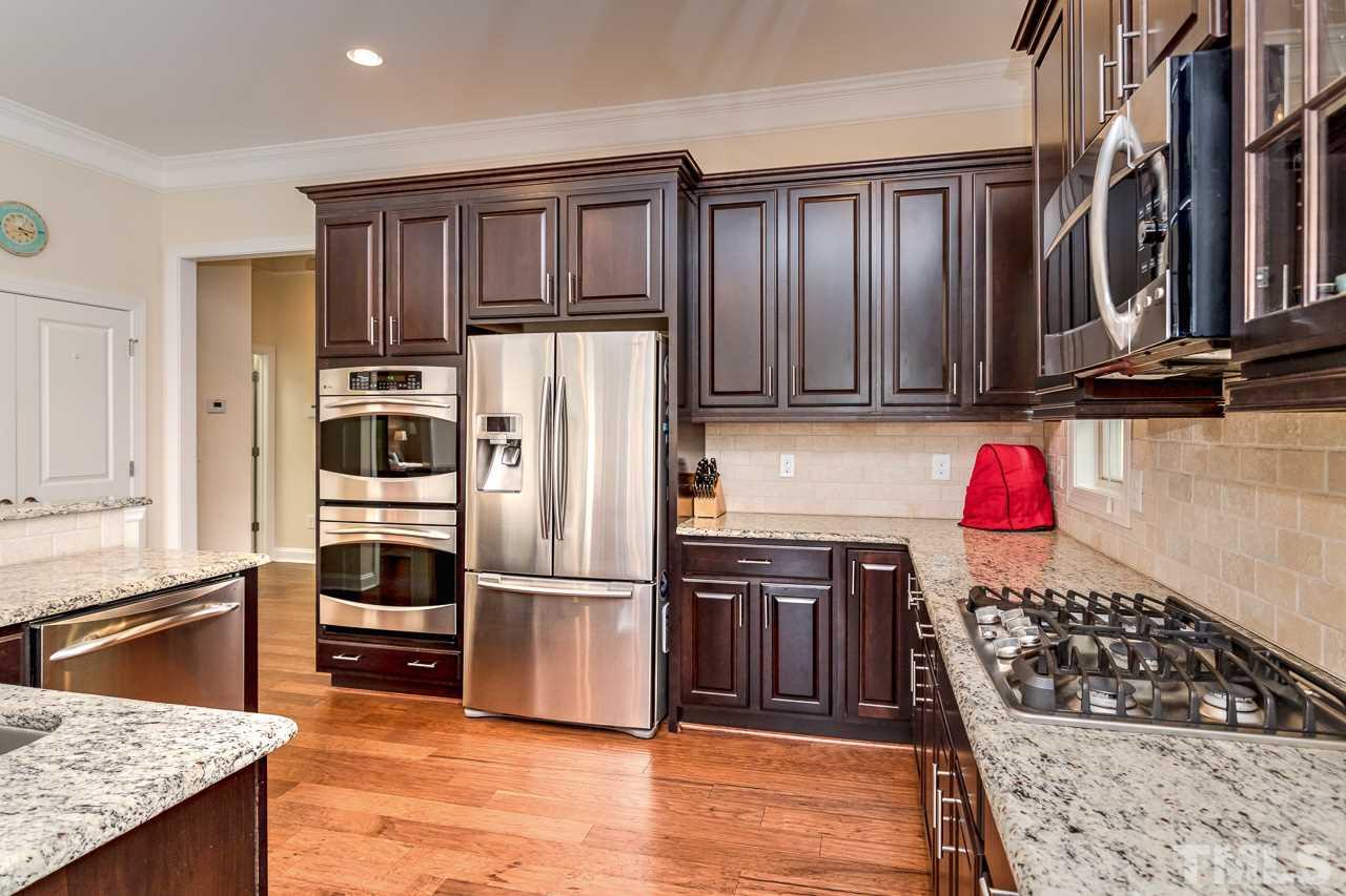 1409 Rodessa Run Raleigh, NC 27607 - Photo 7 of 25 a kitchen with stainless steel appliances granite countertop a refrigerator stove and oven