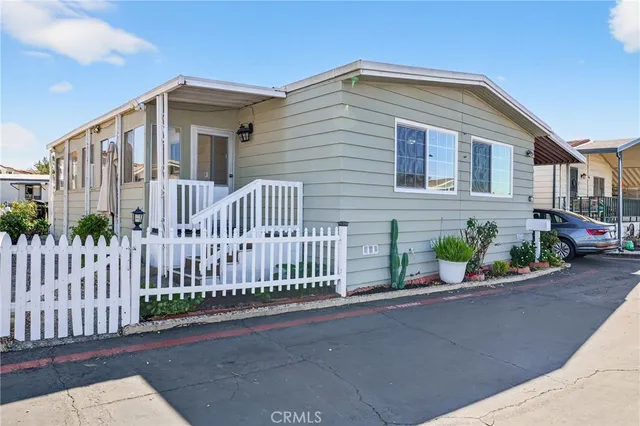 a view of a house with a yard and potted plants