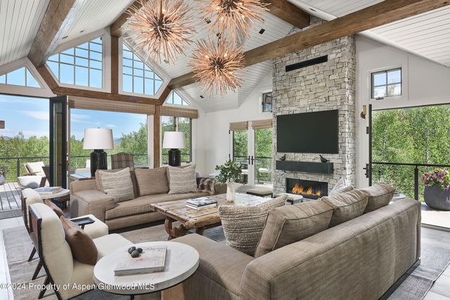 a living room with fireplace furniture and a large window