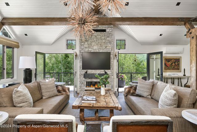 a living room with furniture a large window and a flat screen tv