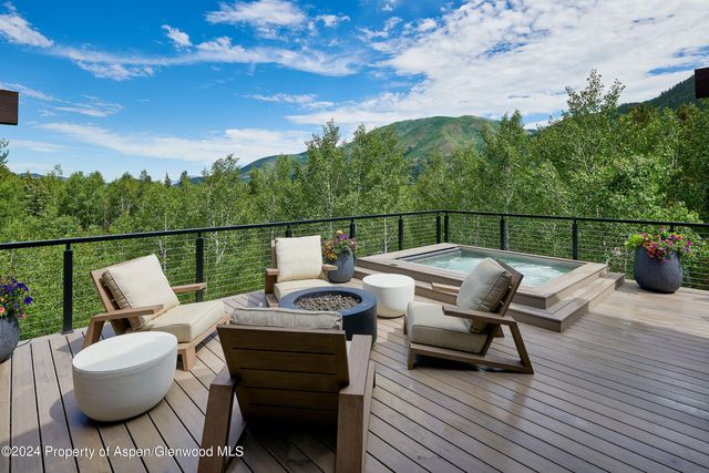 a balcony with wooden floor and outdoor seating