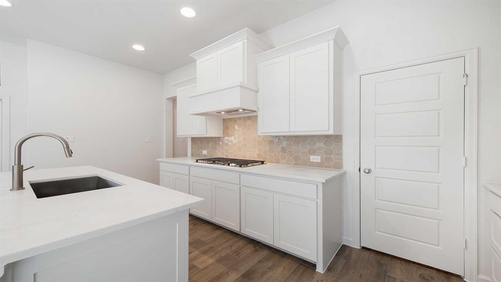 6108 Vester Trail Fate, TX 75087 - Photo 12 of 21 a kitchen with a sink a stove and white cabinets