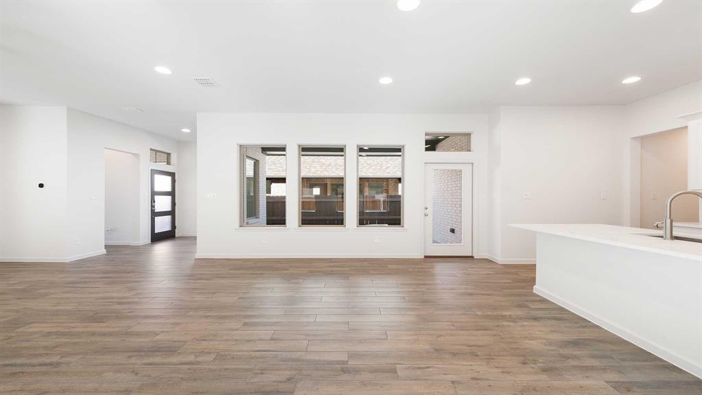 6108 Vester Trail Fate, TX 75087 - Photo 13 of 21 a view of an empty room with wooden floor and a cabinet