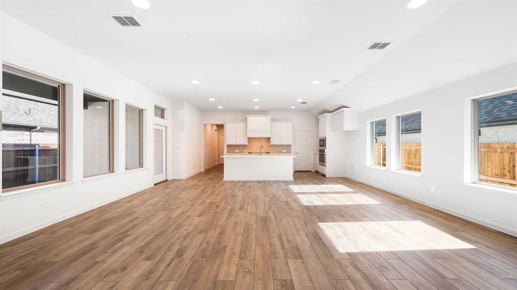 6108 Vester Trail Fate, TX 75087 - Photo 2 of 21 a view of an empty room with wooden floor and a window