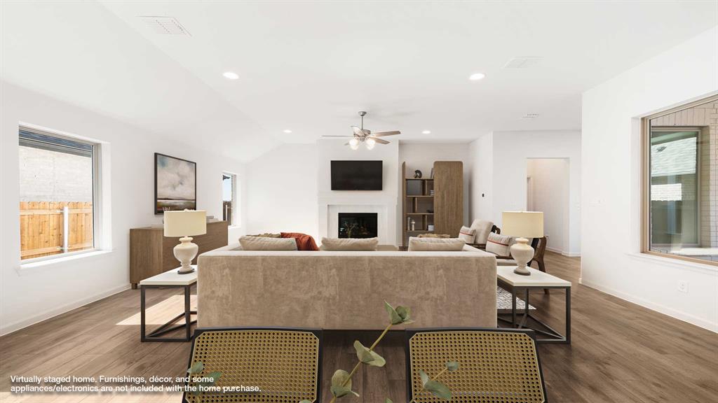 6108 Vester Trail Fate, TX 75087 - Photo 5 of 21 a living room with a couch dining table wooden floor and a fireplace