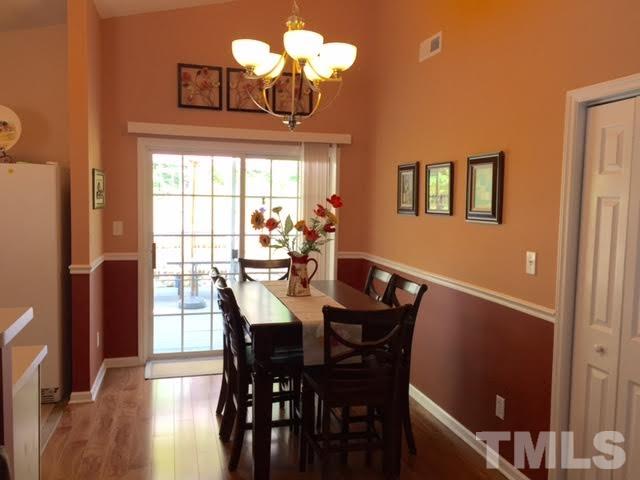 4708 Silverdene Street Raleigh, NC 27616 - Photo 2 of 14 a view of a dining room with furniture a chandelier and wooden floor