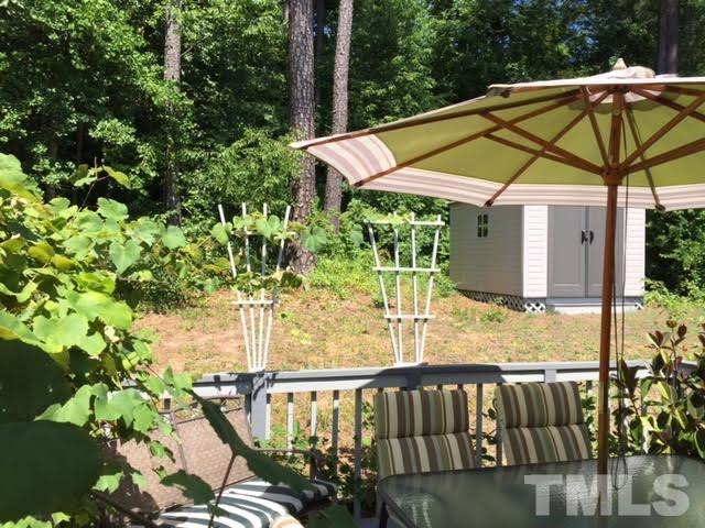4708 Silverdene Street Raleigh, NC 27616 - Photo 6 of 14 a backyard of a house with table and chairs under an umbrella