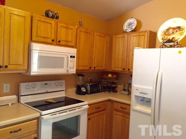 4708 Silverdene Street Raleigh, NC 27616 - Photo 9 of 14 a kitchen with a refrigerator a stove top oven and a sink