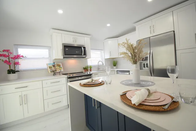 a kitchen with white cabinets and wooden floor
