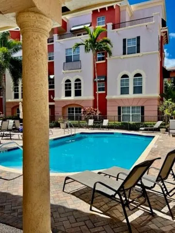 a view of a building with a yard and sitting area