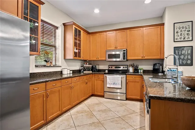 a kitchen with stainless steel appliances granite countertop a stove a sink and a microwave