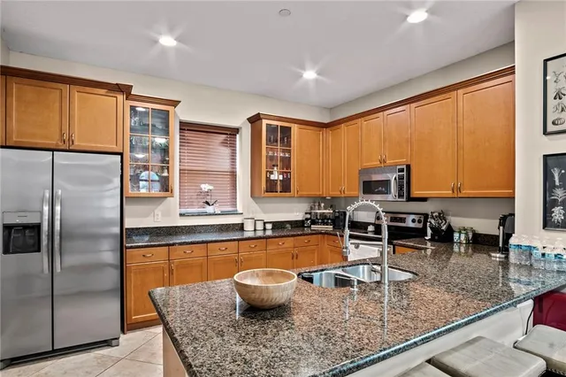 a dining hall with stainless steel appliances a stove a dining table and chairs