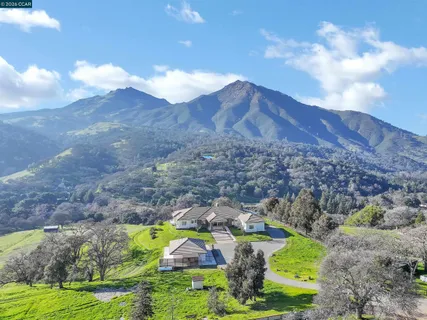 a view of a house with a yard and mountain view