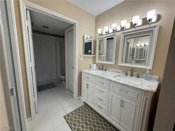 a bathroom with a granite countertop sink a mirror and a shower