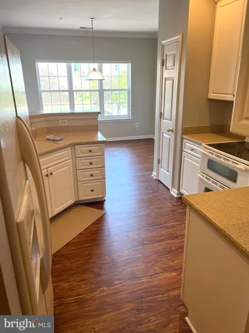 a kitchen with stainless steel appliances granite countertop a refrigerator a stove and a sink with wooden floor