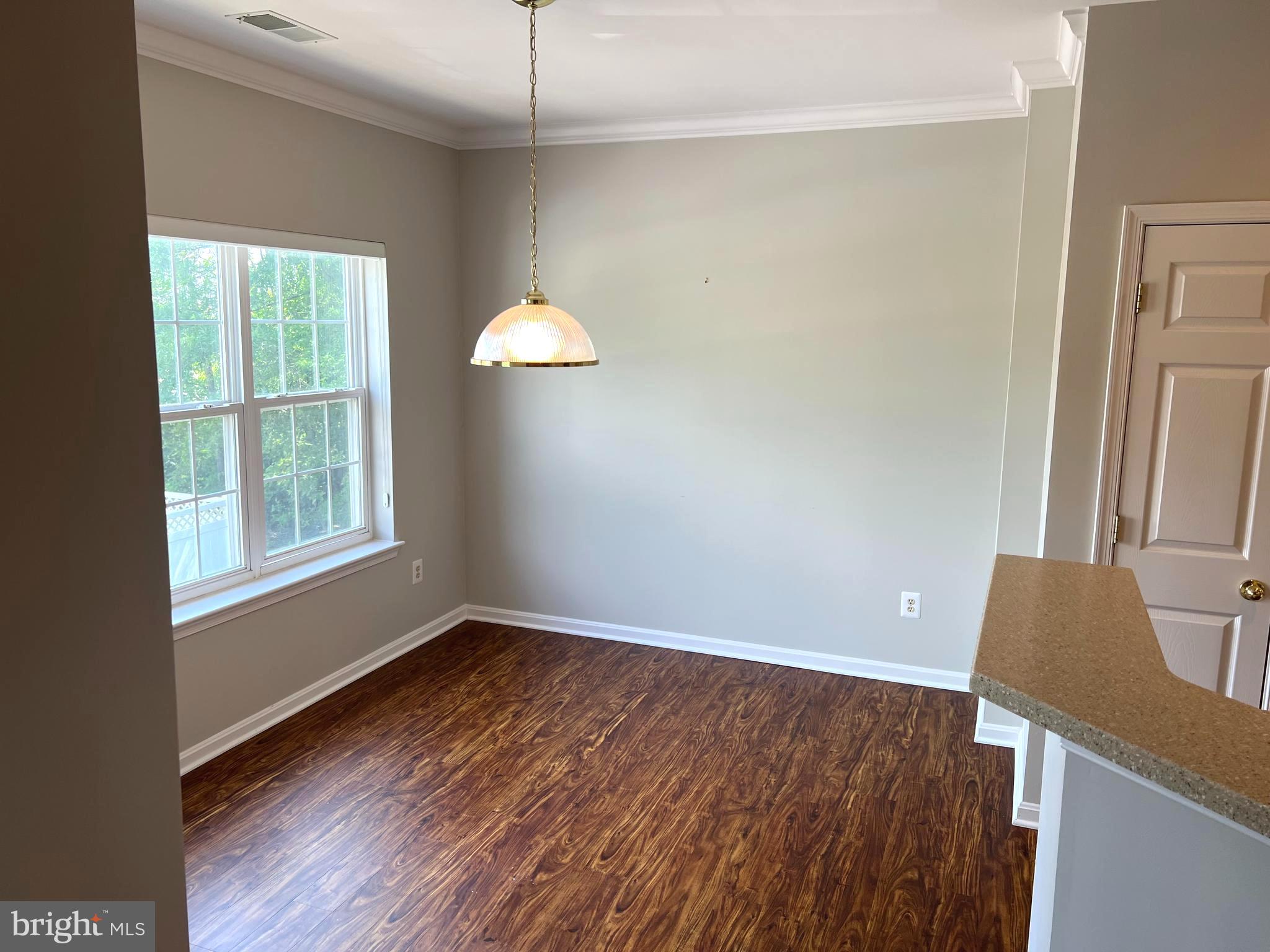 431 Hopkins Landing Drive, Unit 431 Baltimore, MD 21221 - Photo 20 of 30 a view of an empty room with wooden floor and a window