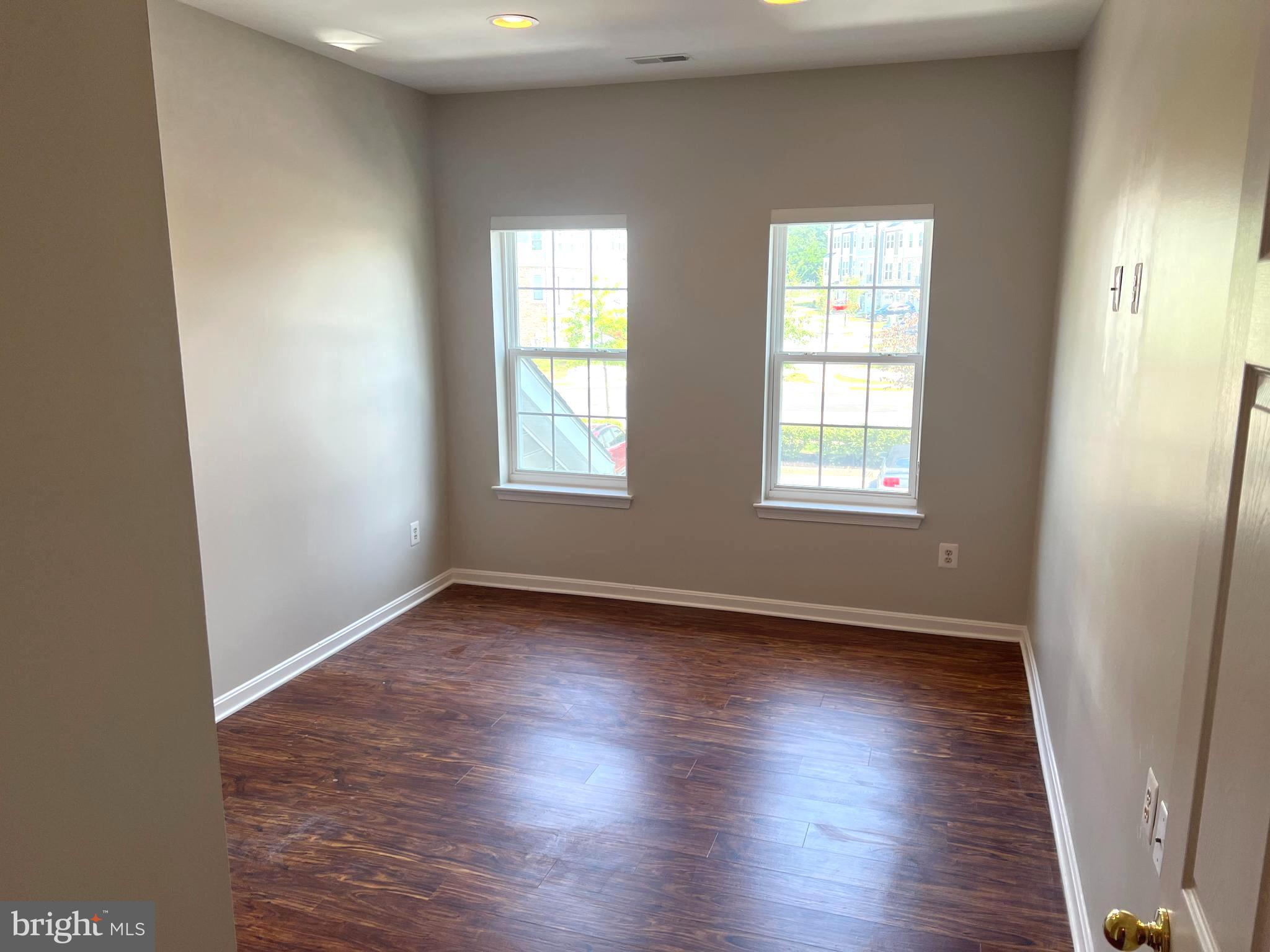 431 Hopkins Landing Drive, Unit 431 Baltimore, MD 21221 - Photo 22 of 30 an empty room with wooden floor and windows
