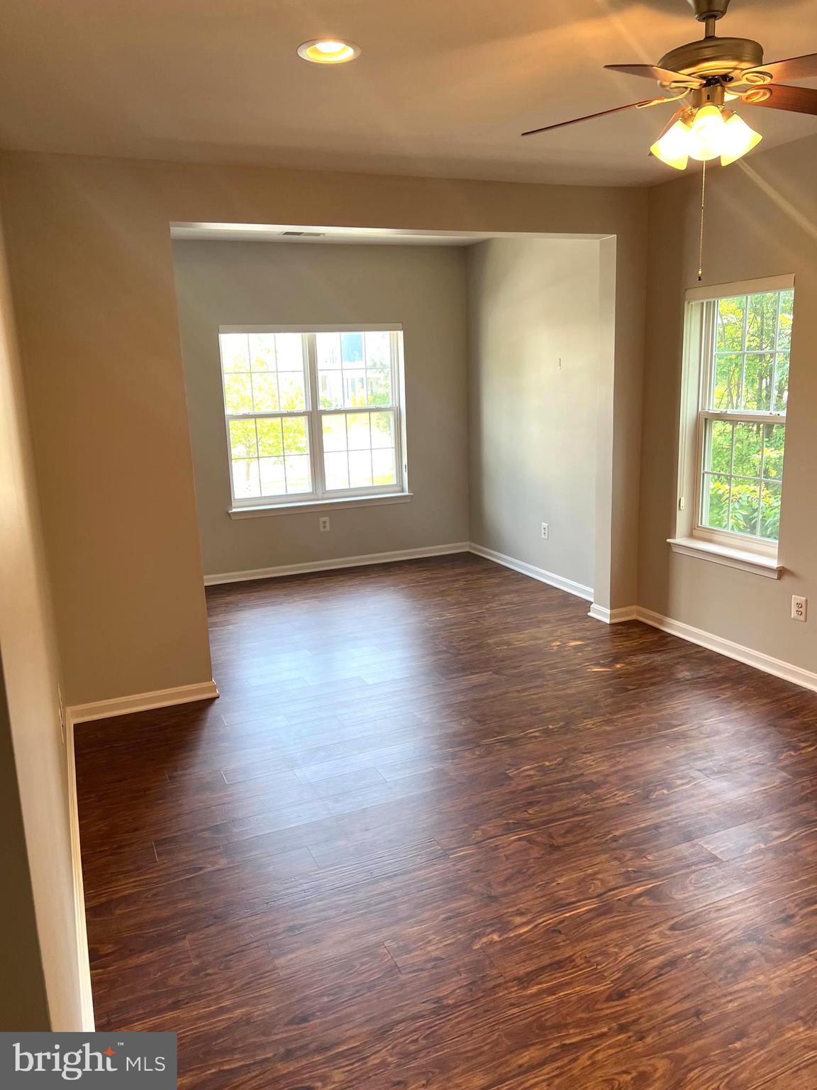 431 Hopkins Landing Drive, Unit 431 Baltimore, MD 21221 - Photo 9 of 30 an empty room with wooden floor chandelier fan and windows