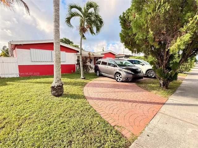 a multi story parking space with potted plants and large trees