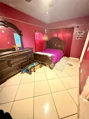 a bedroom with a large bed and a potted plant