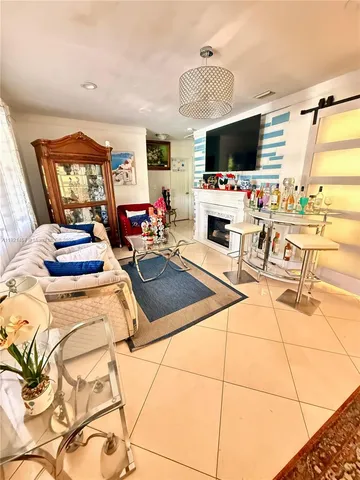 a living room with patio furniture and a flat screen tv