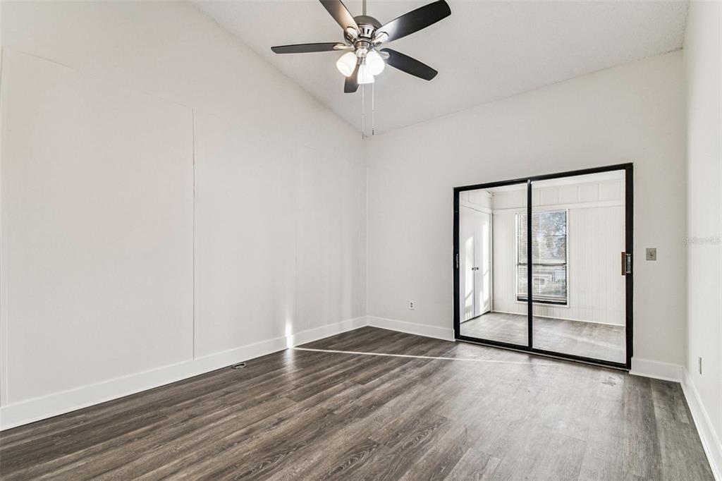 1734 Rumar Lane, Unit A Holiday, FL 34691 - Photo 59 of 100 an empty room with wooden floor fan and windows
