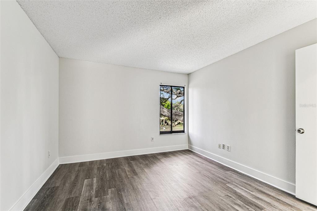 1734 Rumar Lane, Unit A Holiday, FL 34691 - Photo 71 of 100 an empty room with wooden floor and windows