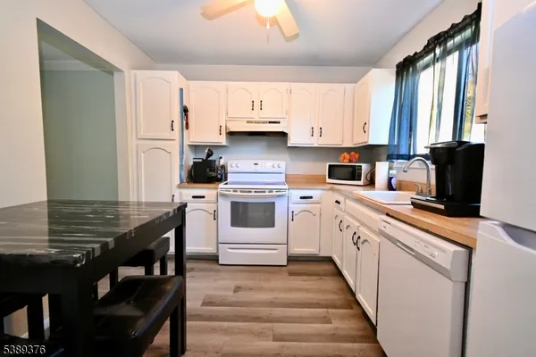 a kitchen with granite countertop a sink appliances cabinets and furniture