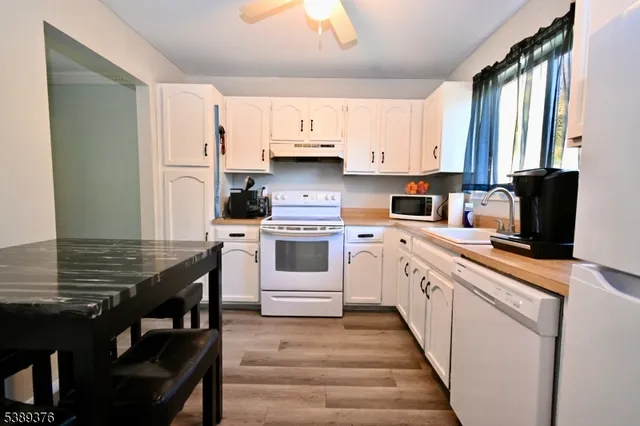 a kitchen with granite countertop a sink appliances cabinets and furniture