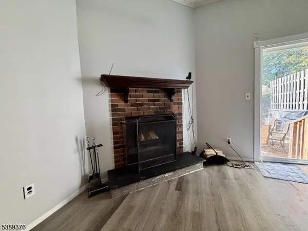 an empty room with windows and fireplace