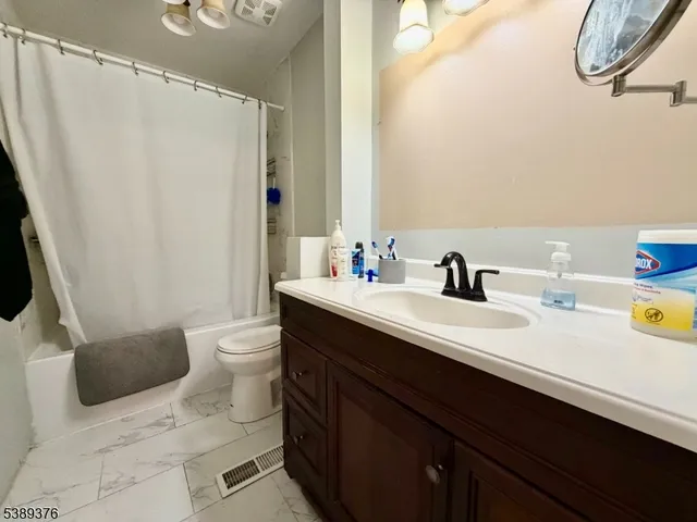a bathroom with a sink a toilet and a mirror