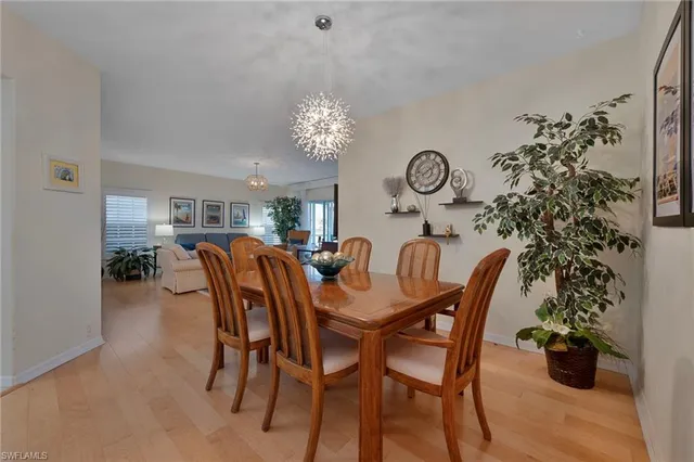 a dining room with furniture potted plants and wooden floor