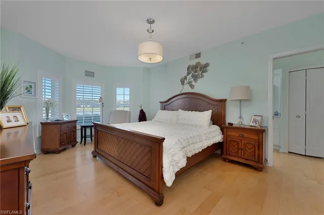 a bedroom with a large bed and a chandelier fan