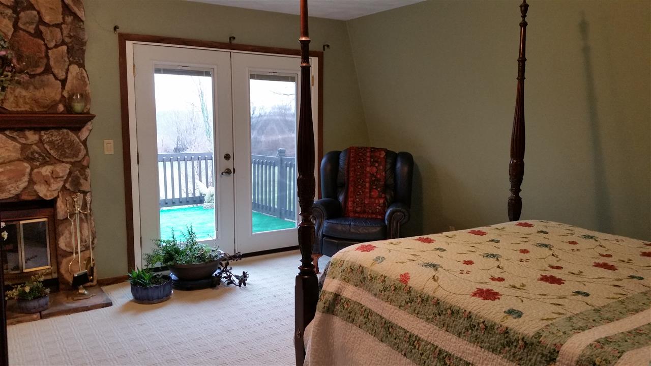 353 Cummings Road Caledonia, IL 61011 - Photo 11 of 24 a bedroom with a bed a table and potted plants