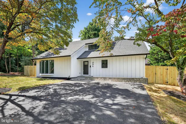a view of a house with a yard and large tree