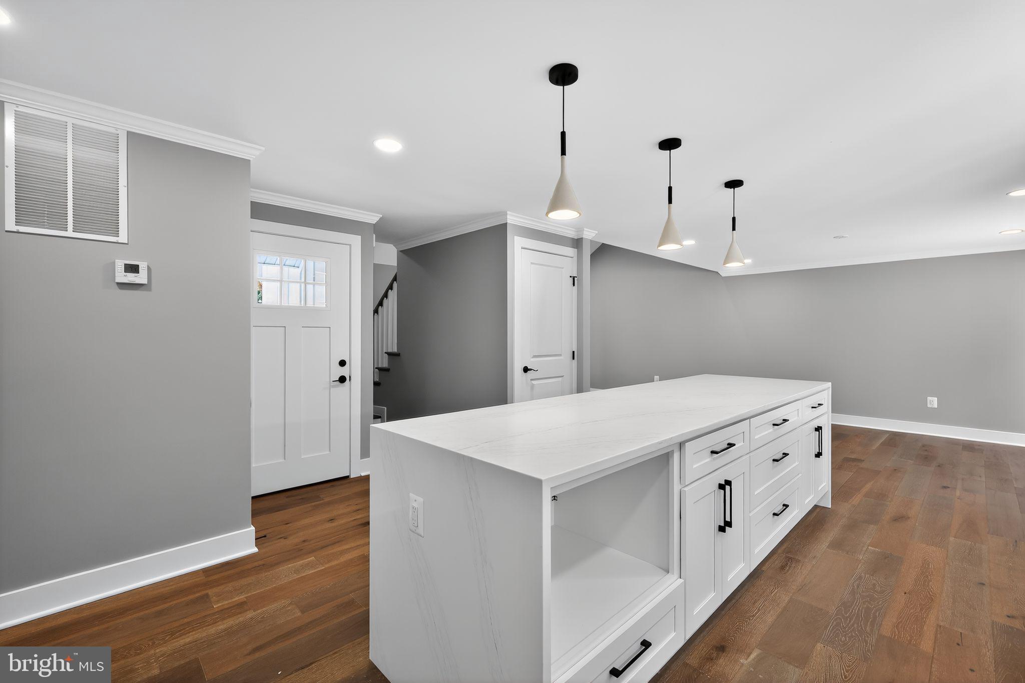 1 Tucker Street Annapolis, MD 21401 - Photo 11 of 46 a hall with kitchen island white cabinets and wooden floor