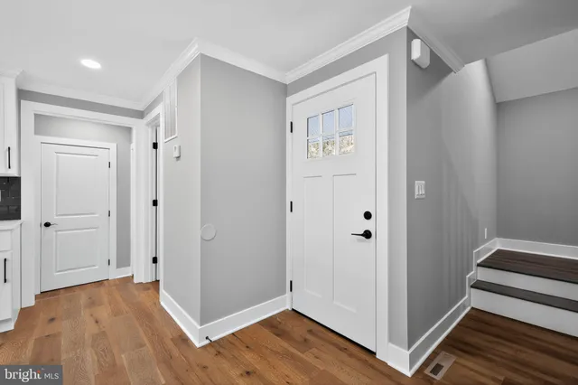a view of empty room with wooden floor and window