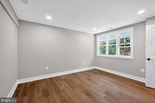 a view of an empty room with wooden floor