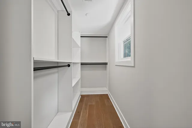an empty room with wooden floor and window