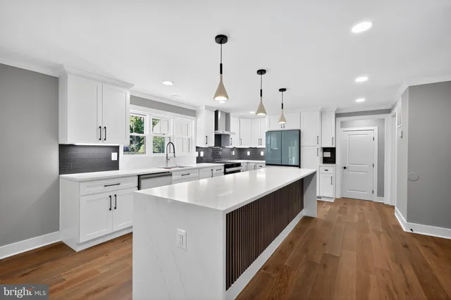 a large kitchen with kitchen island a sink a center island stainless steel appliances and a window
