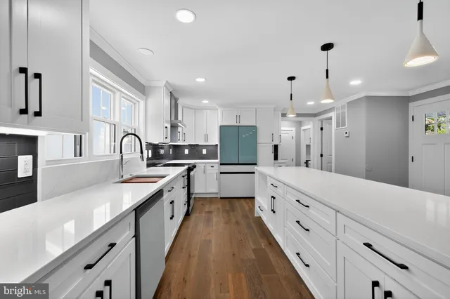 a large kitchen with granite countertop a large counter top space a sink stainless steel appliances and cabinets