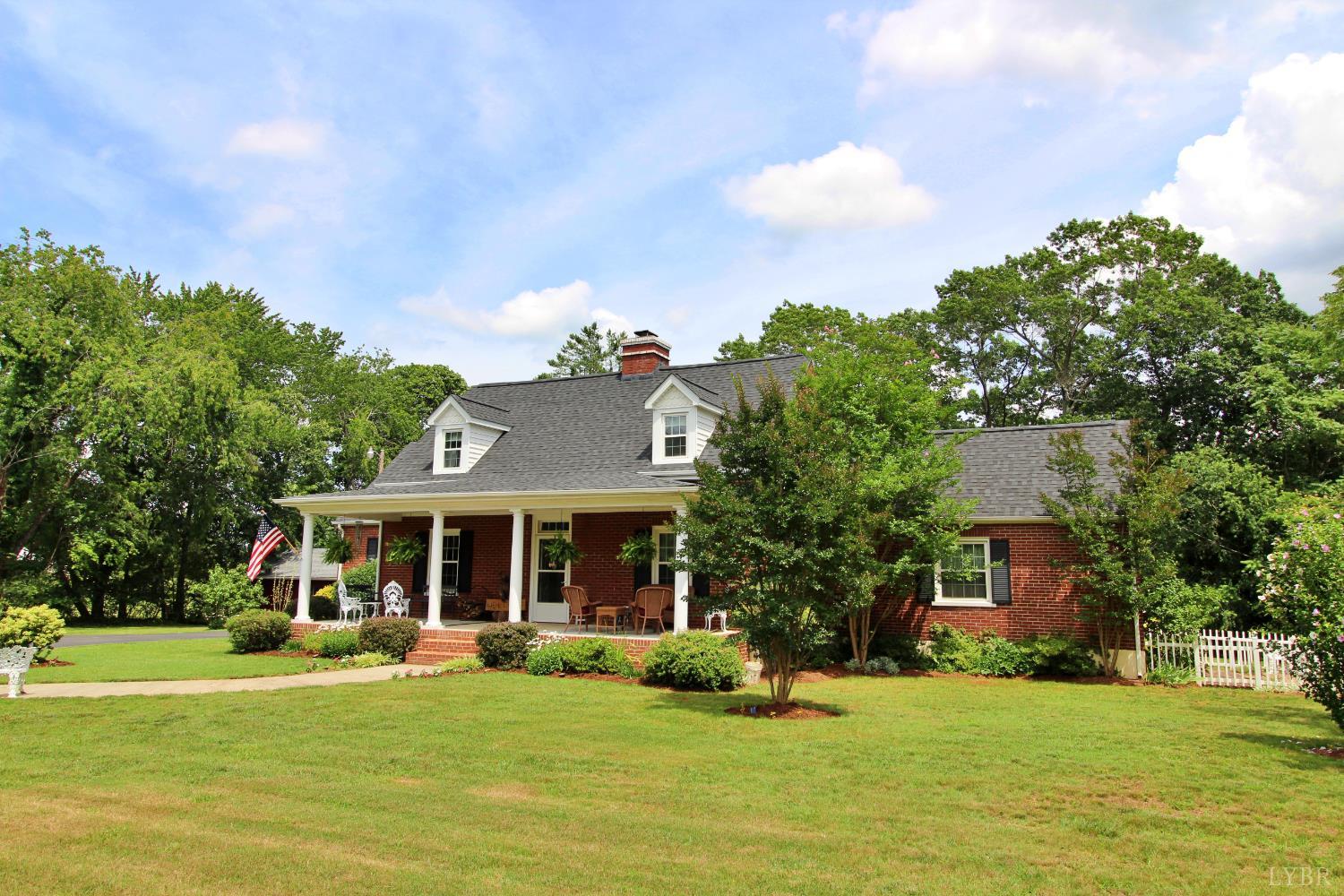 a front view of a house with a garden and trees
