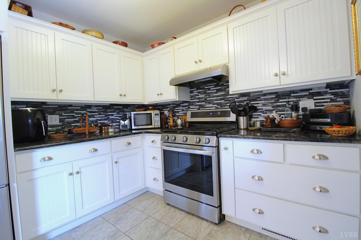 1538 Redfields Road Appomattox, VA 24522 - Photo 17 of 60 a kitchen with white cabinets and appliances