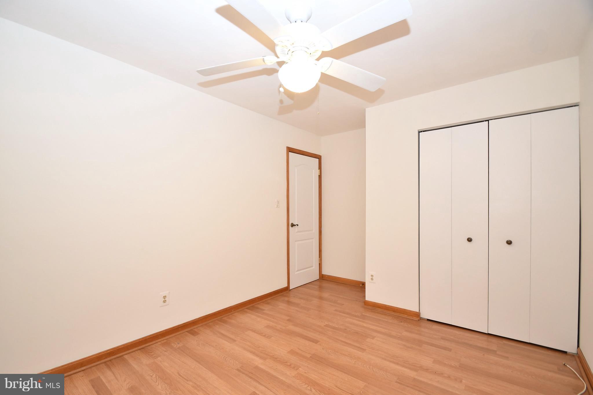 202 Sandhill Road Baltimore, MD 21221 - Photo 17 of 30 an empty room with wooden floor fan and windows