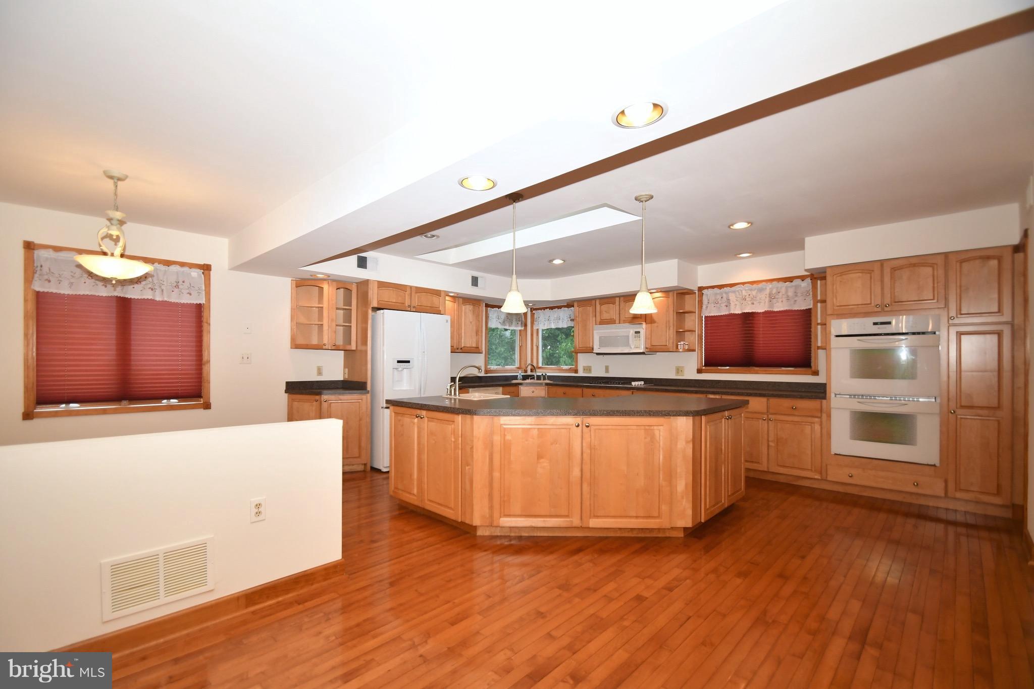 202 Sandhill Road Baltimore, MD 21221 - Photo 3 of 30 a large kitchen with stainless steel appliances a large counter top a stove and a refrigerator