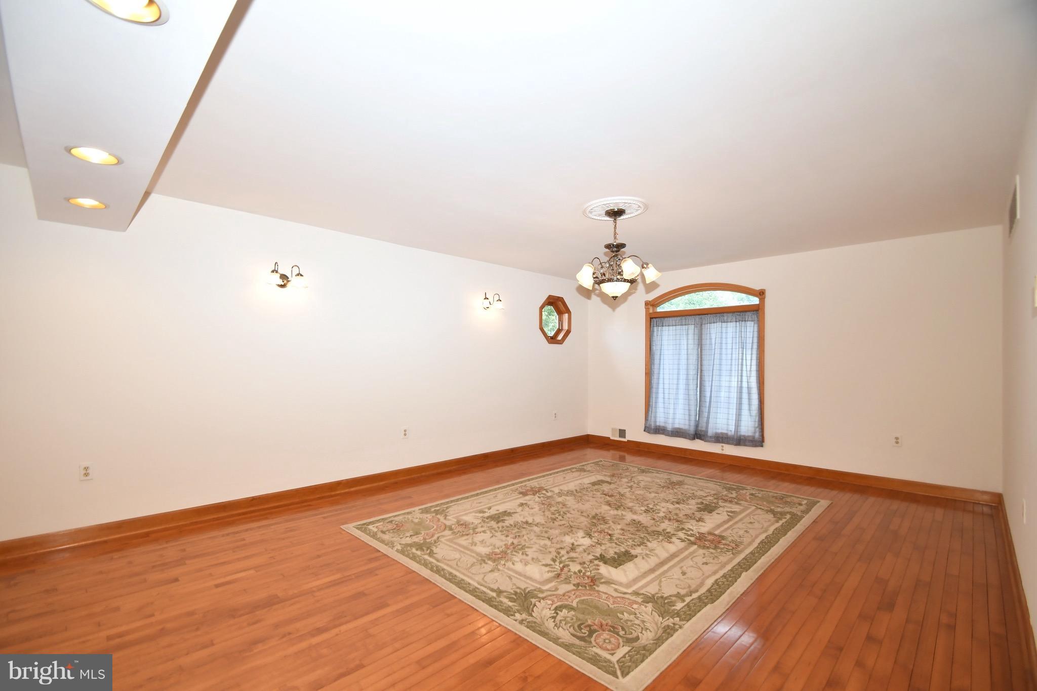 202 Sandhill Road Baltimore, MD 21221 - Photo 6 of 30 an empty room with wooden floor and white walls