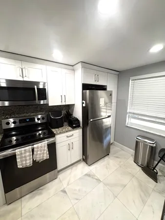 a kitchen with stainless steel appliances granite countertop a refrigerator a stove a sink and a microwave