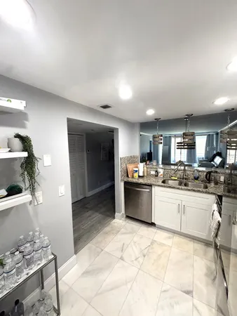 a kitchen with stainless steel appliances kitchen island granite countertop a sink and cabinets